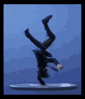 a man in a suit is doing a handstand on a platform .