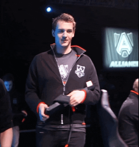 a man wearing a black jacket with the letter a on it