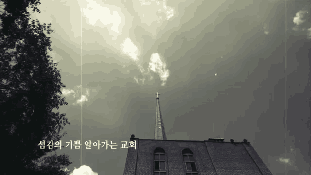 a black and white photo of a church steeple with a cross on top