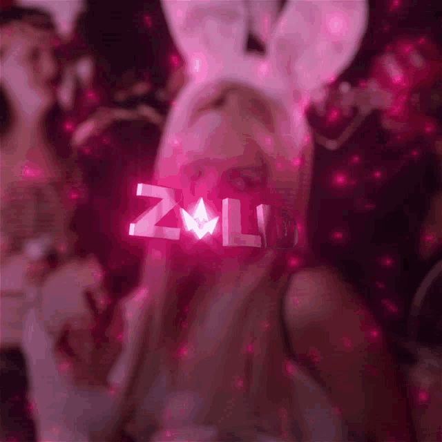 a woman wearing bunny ears has the word zald written in pink on her face
