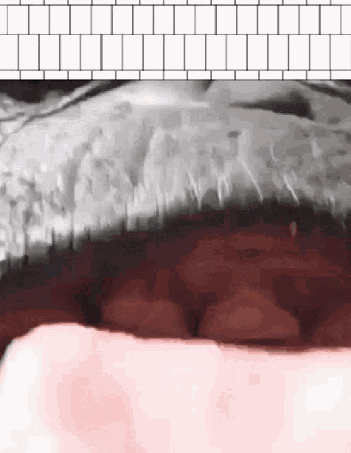 a close up of a person 's mouth with a white brick wall in the background