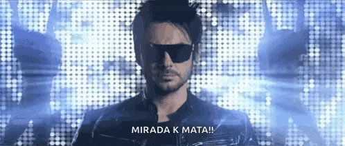 a man wearing sunglasses and a leather jacket is standing in front of a blue background and says mirada k mata .