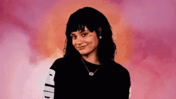 a woman wearing a black sweater with the word puma on it is smiling .