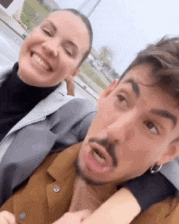 a man and a woman are posing for a picture together .