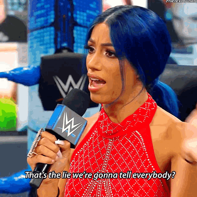 a woman with blue hair is holding a microphone and says that 's the lie we 're gonna tell everybody '