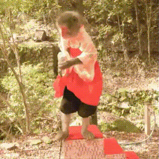 a monkey wearing a red and white kimono is standing on a red mat .