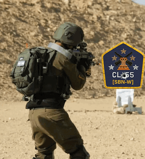 a soldier is holding a rifle in front of a badge that says class sbn-w
