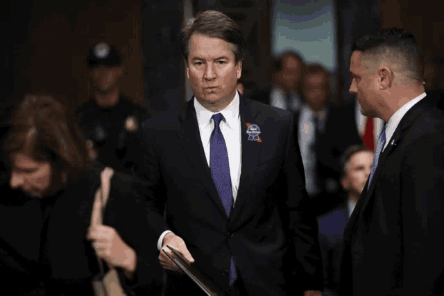 a man in a suit and tie has a sticker in his pocket that says ' freedom ' on it