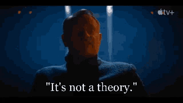 a man in a dark room is talking about a theory .