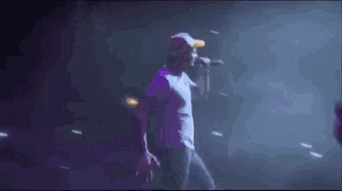 a man is singing into a microphone on stage