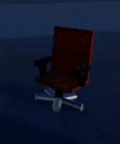 a red office chair is sitting in the dark in a room .