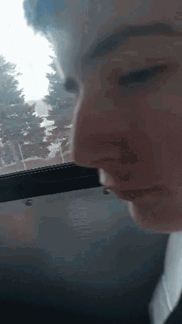 a close up of a person 's face in a car