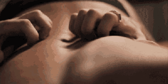 a close up of a woman 's stomach with her hands on it