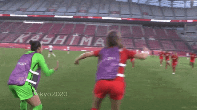 a group of female soccer players are playing a game of soccer on a field .