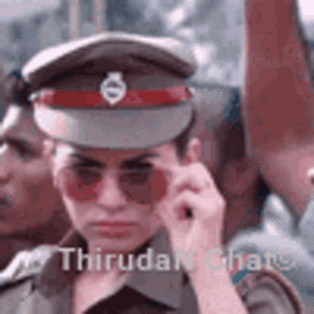 a woman in a police uniform and sunglasses is talking on a cell phone .