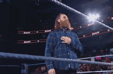 a man is holding a rope in a wrestling ring with the word raw on it