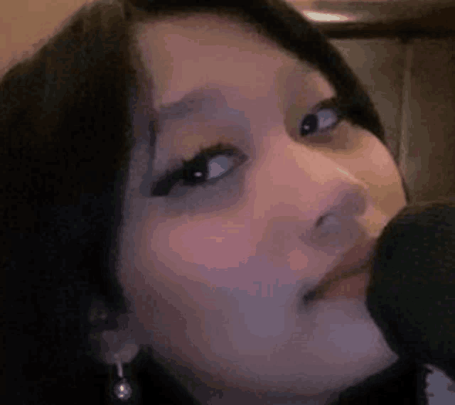 a close up of a woman 's face while holding a microphone .