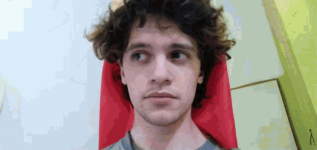 a man with curly hair is upside down and looking down
