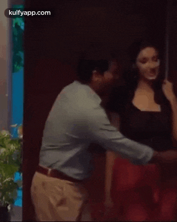 a man is hugging a woman in a room .