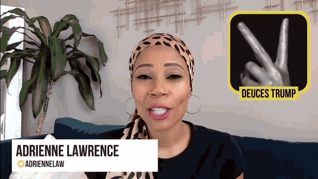 adrienne lawrence is sitting on a blue couch with a plant in the background