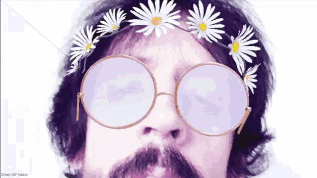 a man with a beard wearing glasses and a headband of daisies