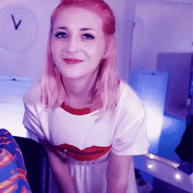 a woman with pink hair is wearing a t-shirt with red lips on it