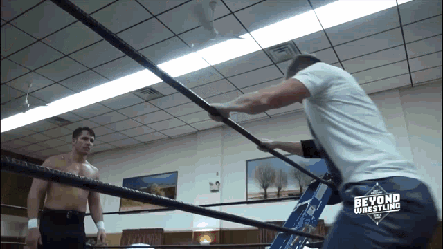 two men in a wrestling ring with the words beyond wrestling on the back of their pants