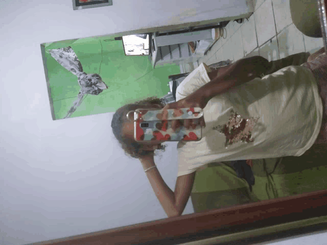 a woman taking a picture of herself in a mirror with her phone
