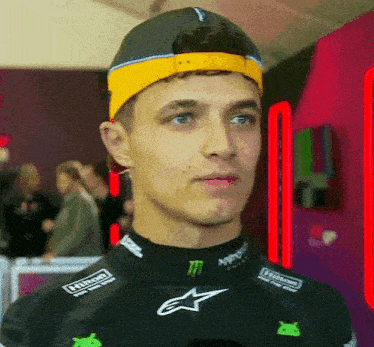 a man wearing a black shirt and a yellow headband is looking at the camera .