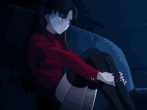 a girl in a red shirt sits on a couch