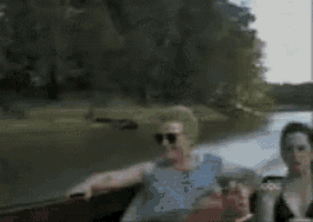 a blurred image of a person standing next to a red boat that says abc on it