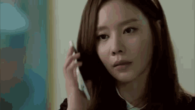 a woman is talking on a cell phone and making a sad face .