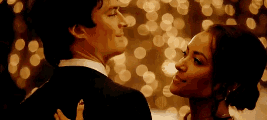 a man in a suit and a woman in a dress are dancing