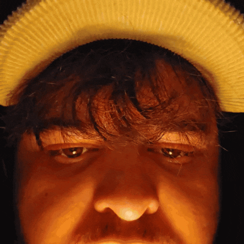 a close up of a person 's face with a yellow hat on