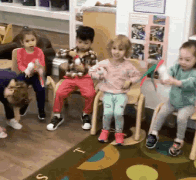 a group of children are playing with toys in a classroom with the letter t on the rug