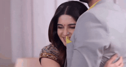 a man and a woman are hugging each other .