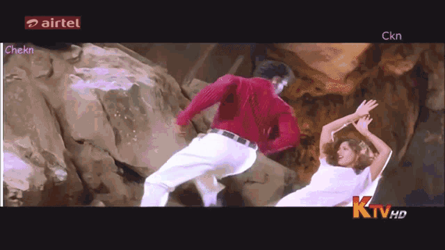a man in a red shirt is dancing with a woman in white