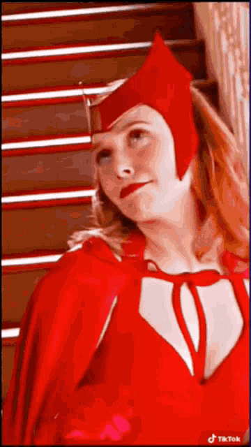 a woman in a scarlet witch costume is standing in front of some stairs .