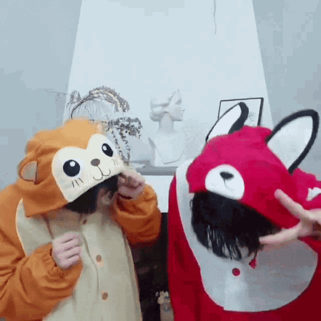 two people wearing monkey and fox costumes are making peace signs