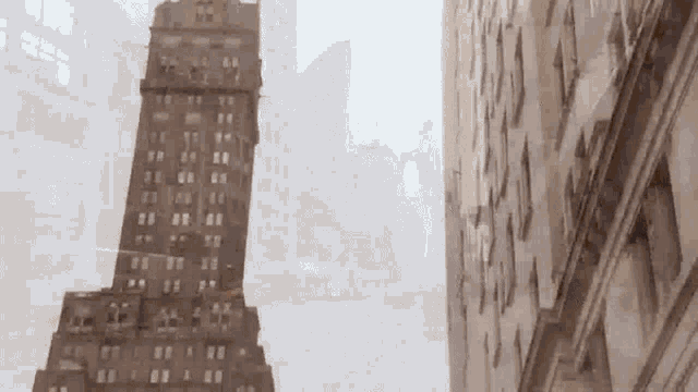 a tall building with a lot of windows is surrounded by other buildings in the city .