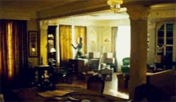 a living room with a ceiling fan and a few chairs