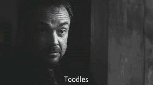 a black and white photo of a man peeking out from behind a door with the words toodles written on the bottom .