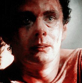 a close up of a man 's face with blood on his face
