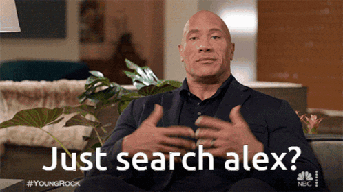 a man in a suit is sitting on a couch with the words just search alex