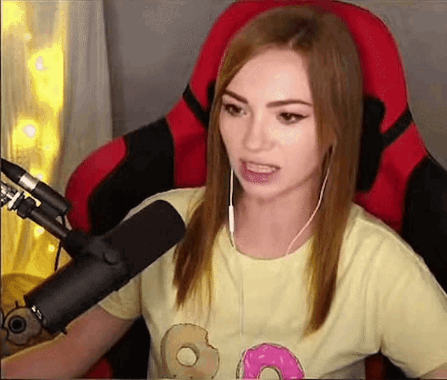 a young woman is sitting in a red chair in front of a microphone .