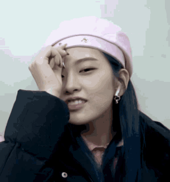 a woman wearing a pink hat and ear buds