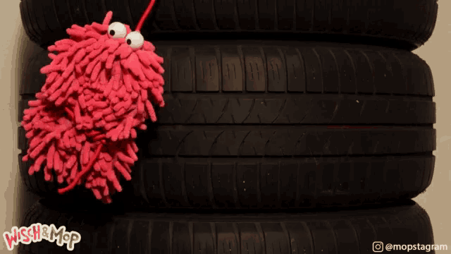 a picture of a stack of tires with a red mop in the middle