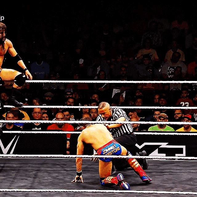 a wrestler in a wrestling ring with a referee and a sign that says wrestling on it