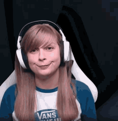 a girl wearing headphones and a vans shirt