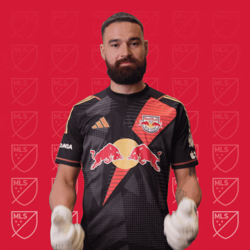a man with a beard wearing a black red bull jersey